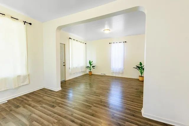 a view of a room with wooden floor and potted plant