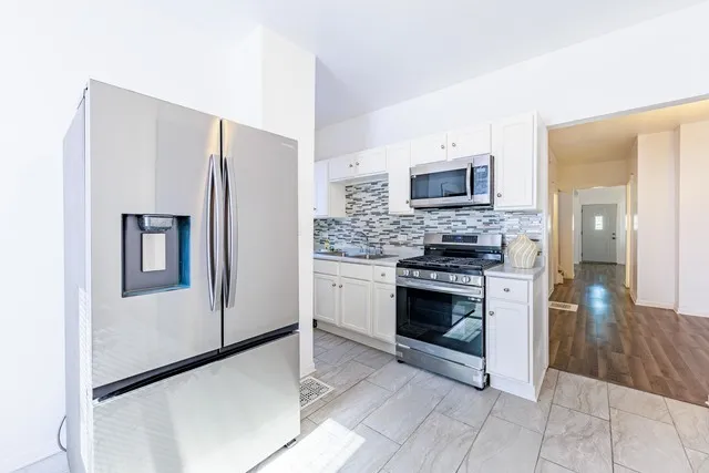 a kitchen with stainless steel appliances granite countertop a stove top oven a refrigerator and a stove