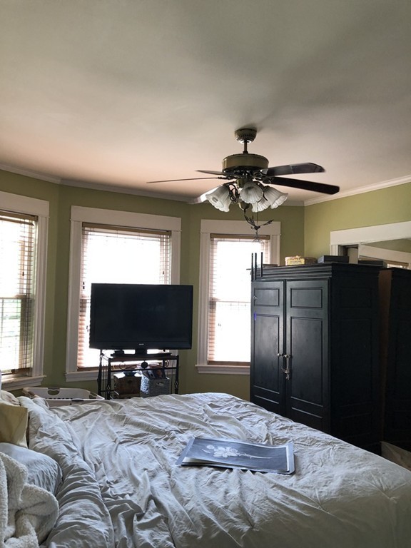 603 Temple Street Whitman, MA 02382 - Photo 3 of 8 a bedroom with a bed and a flat tv screen on dresser