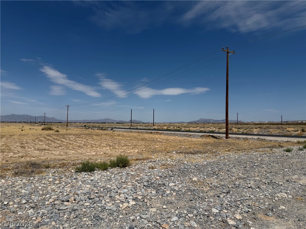 5731 East Gamebird Road Pahrump, NV 89048 - Photo 1 of 3 A vast, arid expanse offers boundless potential for development, framed by distant mountains under an expansive sky.