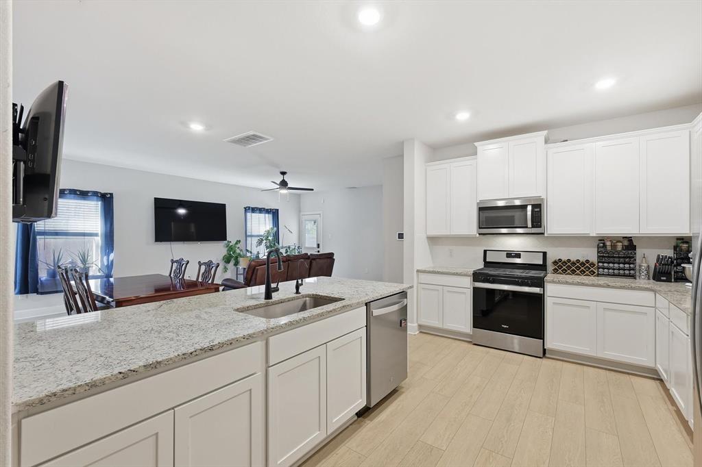 1334 Windemere Way Princeton, TX 75407 - Photo 30 of 31 a kitchen with stainless steel appliances granite countertop a sink and a stove