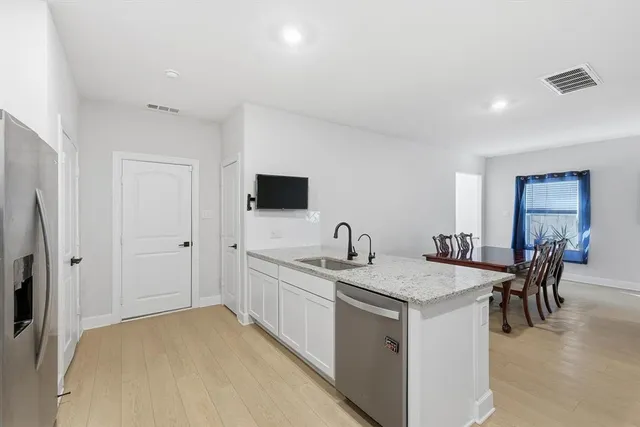a kitchen that has a sink a table and chairs in it