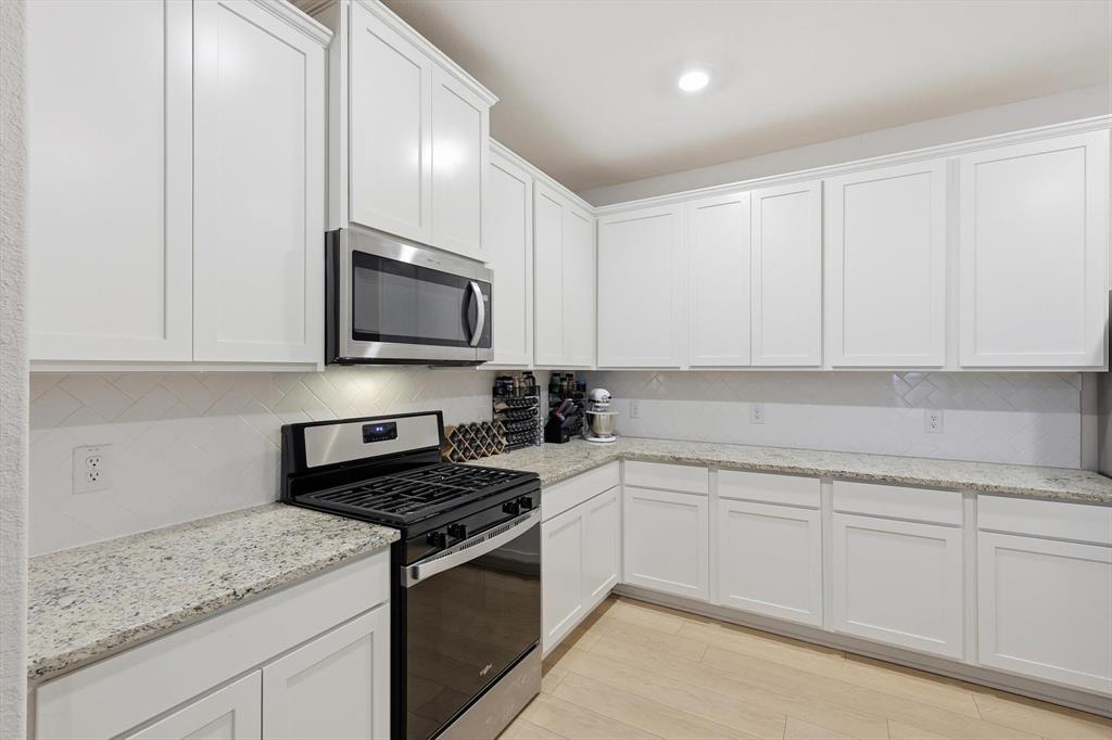 1334 Windemere Way Princeton, TX 75407 - Photo 8 of 31 a kitchen with granite countertop white cabinets and stainless steel appliances