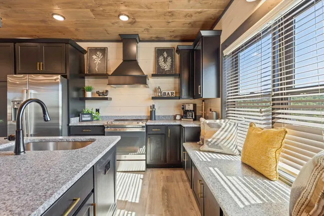 a kitchen with stainless steel appliances granite countertop a sink and white cabinets