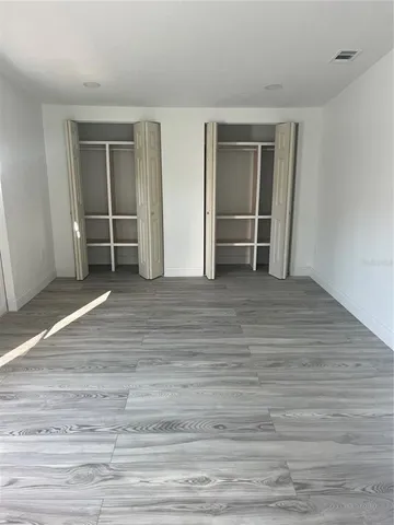 a view of an empty room with closet and cabinet