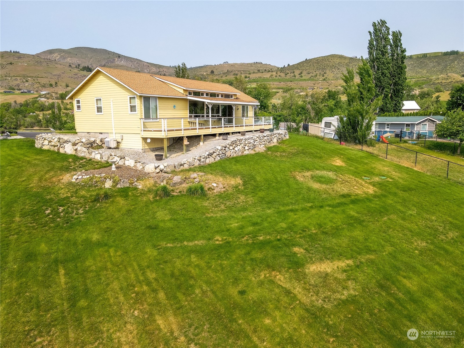 94 Shoemaker Road Manson, WA 98831 - Photo 16 of 37 a view of a house with a big yard and large trees