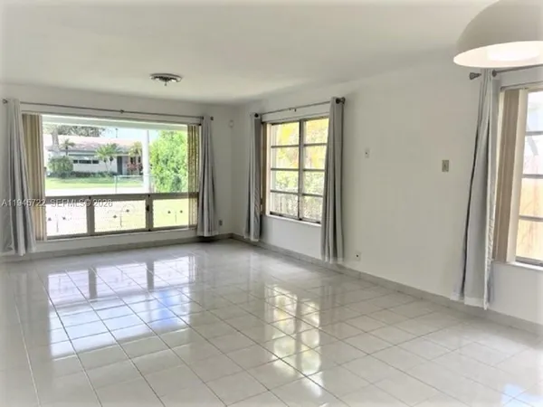 an empty room with windows and entrance