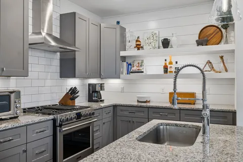 a large kitchen with kitchen island a large counter top space a sink stainless steel appliances and cabinets