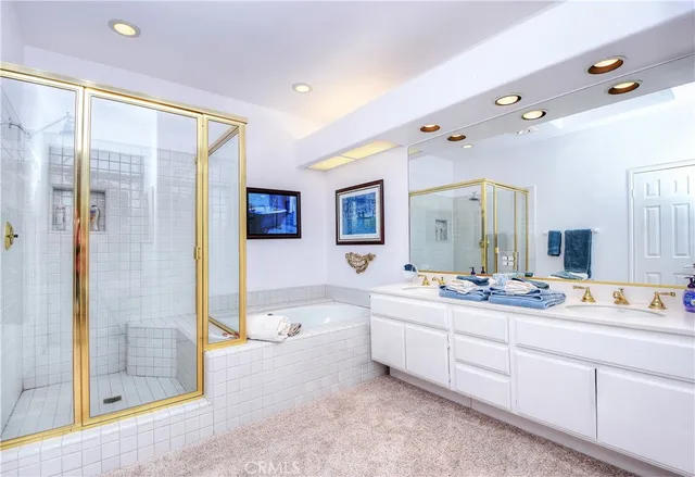 a spacious bathroom with a double vanity sink a mirror a shower and a bathtub
