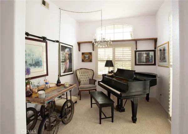 a living room with furniture a chandelier and a window