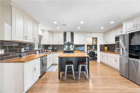 a kitchen with stainless steel appliances granite countertop a table chairs sink refrigerator and cabinets