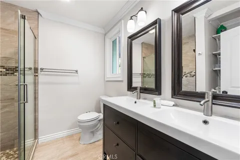 a bathroom with a double vanity sink toilet and mirror