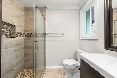 a bathroom with a granite countertop sink a toilet and shower