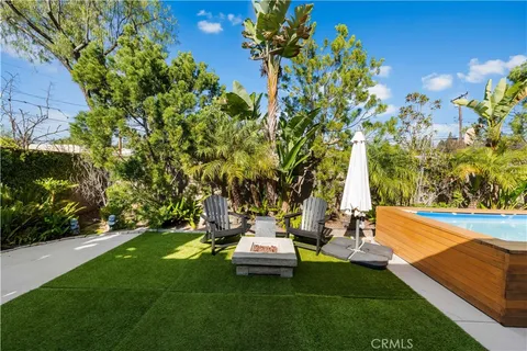 a view of a chair and table in backyard of the house
