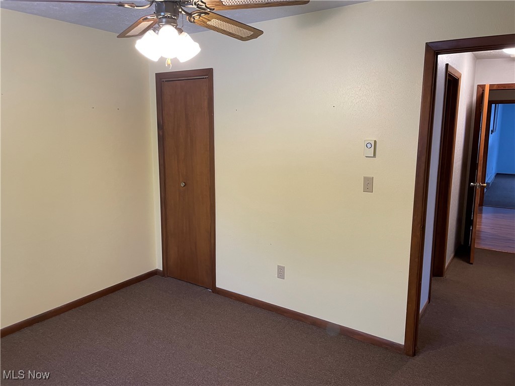 1381 Robb Road Conneaut, OH 44030 - Photo 26 of 50 Empty room featuring dark carpet and a ceiling fan