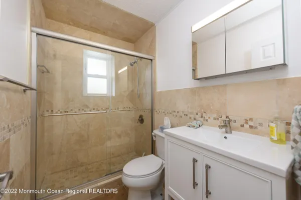 a bathroom with a sink a toilet and a mirror