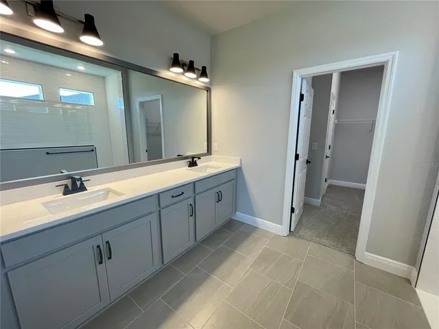 a spacious bathroom with a double vanity sink and mirror