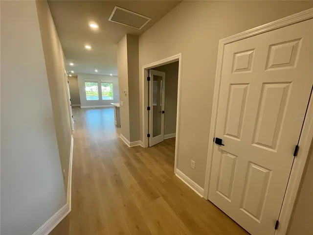 a view of a hallway with wooden floor