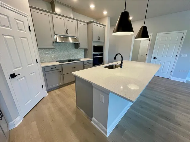 a kitchen with a sink a refrigerator and cabinets