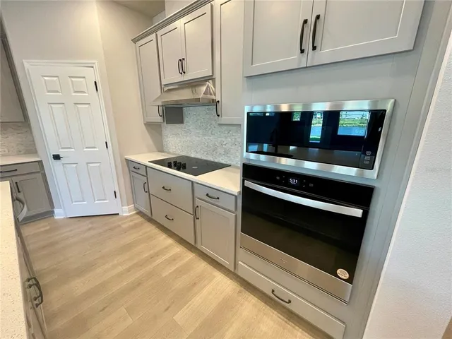 a kitchen with stainless steel appliances white cabinets and stove