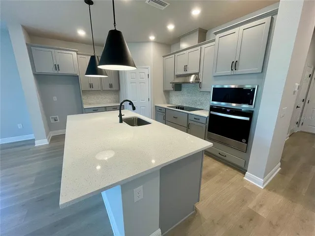 a kitchen with stainless steel appliances a sink a stove a refrigerator and cabinets