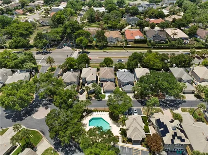 an aerial view of residential houses with outdoor space and trees