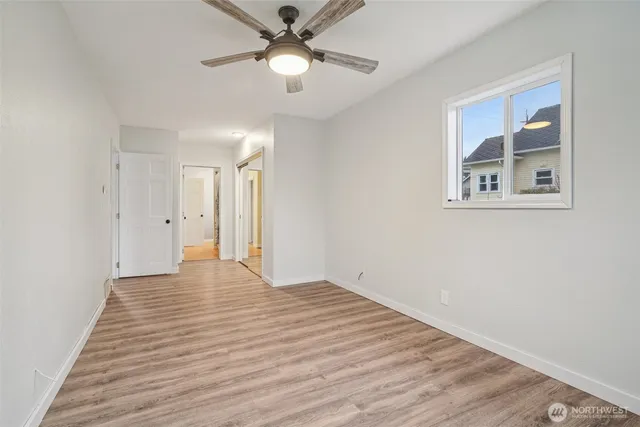 a view of an empty room with a chandelier fan