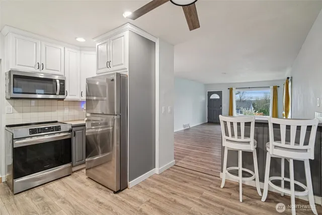a kitchen with stainless steel appliances a stove a refrigerator and a microwave