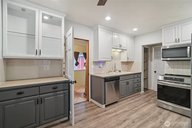 a kitchen with kitchen island granite countertop a sink cabinets and stainless steel appliances