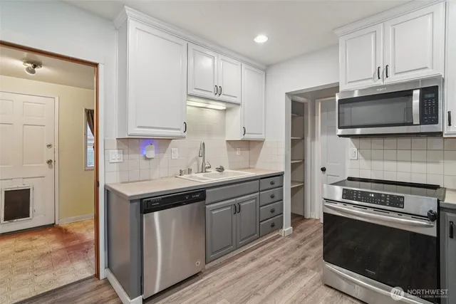 a kitchen with stainless steel appliances a stove microwave and cabinets