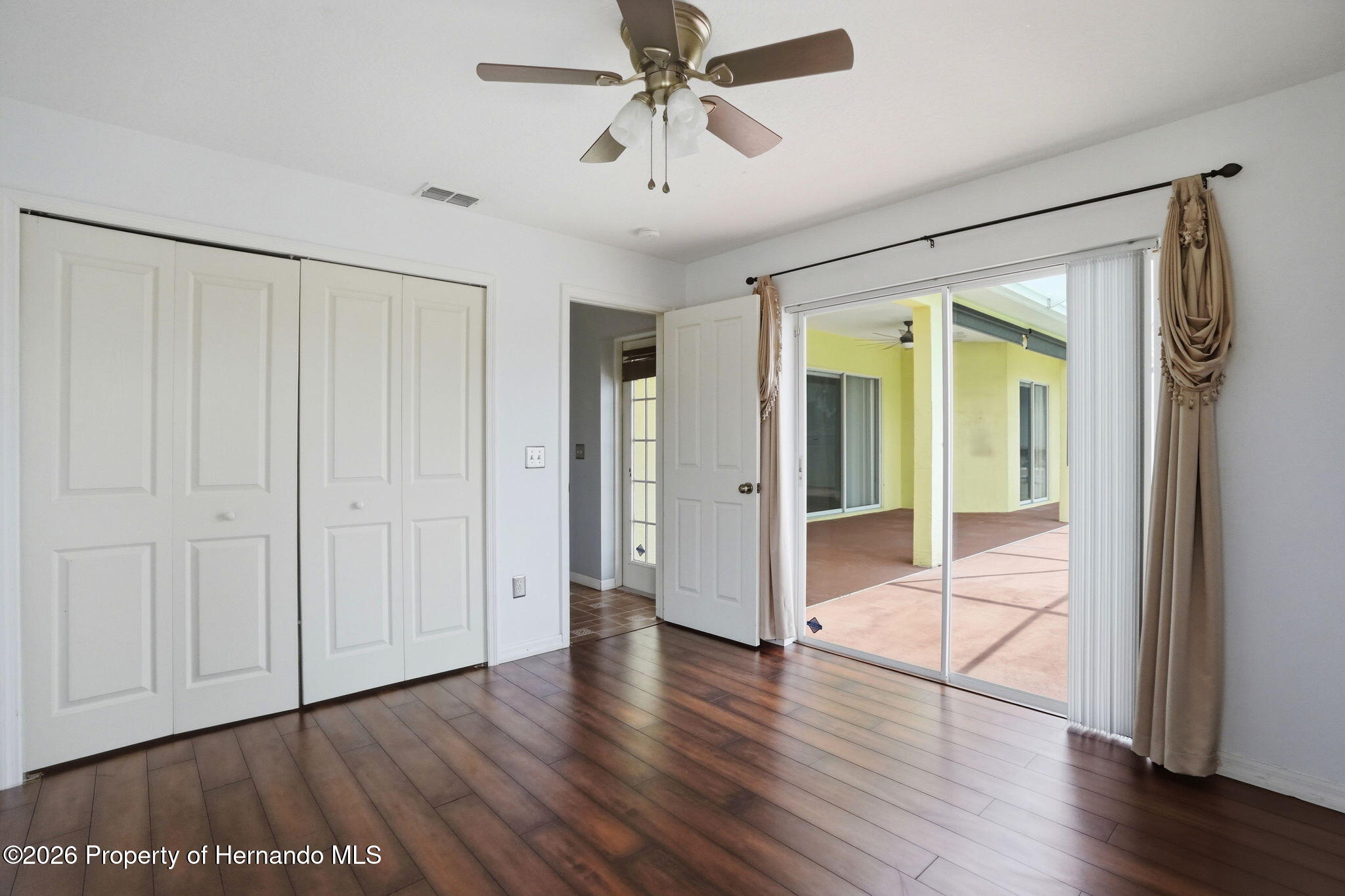 18131 Rivard Boulevard Brooksville, FL 34604 - Photo 41 of 66 an empty room with wooden floor and a ceiling fan