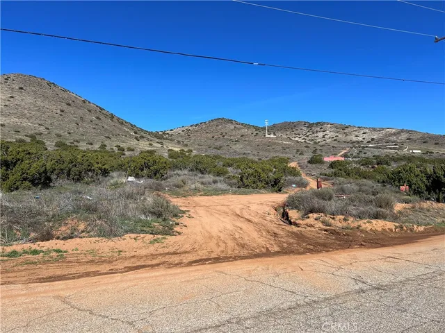 a view of a dry yard with mountains in the background