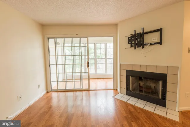 an empty room with windows and fireplace