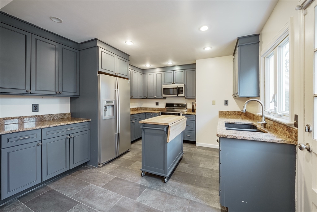 384 Forest Hills Road Springfield, MA 01128 - Photo 10 of 36 a kitchen with a refrigerator sink and wooden cabinets