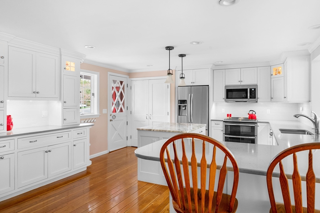 200 Sturbridge Drive Barnstable, MA 02655 - Photo 11 of 39 a kitchen with stainless steel appliances granite countertop a stove a sink dishwasher a refrigerator with white cabinets and wooden floor