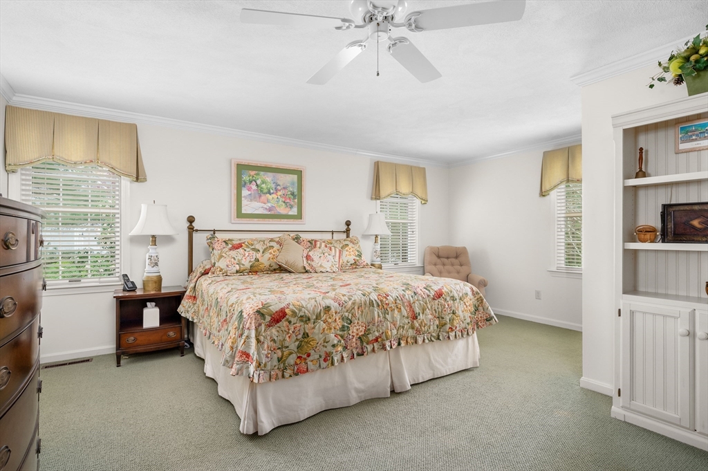 200 Sturbridge Drive Barnstable, MA 02655 - Photo 18 of 39 a spacious bedroom with a bed and a chandelier