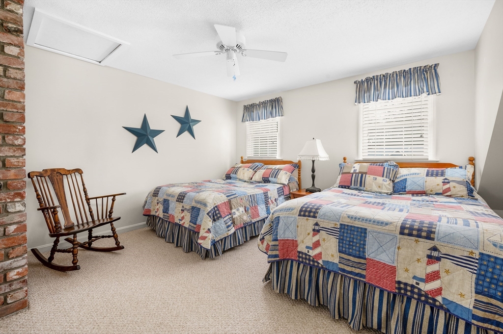 200 Sturbridge Drive Barnstable, MA 02655 - Photo 24 of 39 a bedroom with two beds and a chandelier