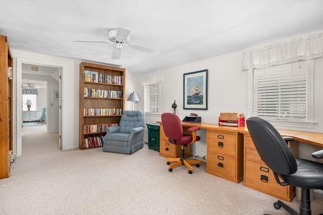 a view of a livingroom with workspace and a window