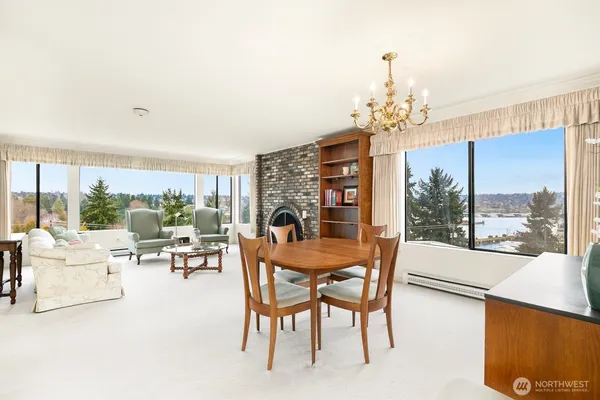 a dining room with furniture a chandelier and large windows
