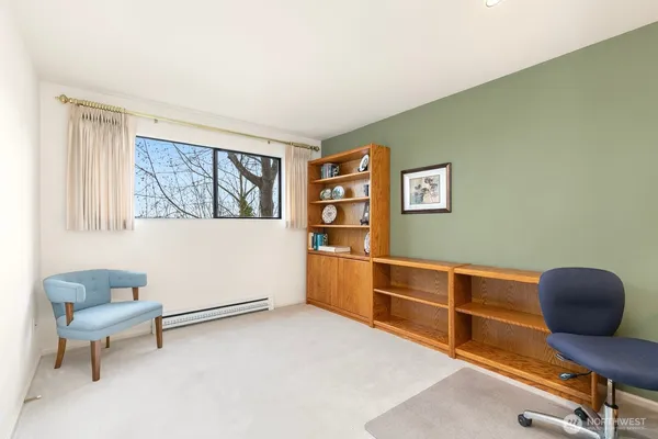 a view of a workspace with furniture and a window