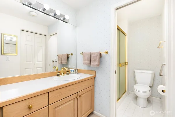 a bathroom with a sink a toilet and a mirror