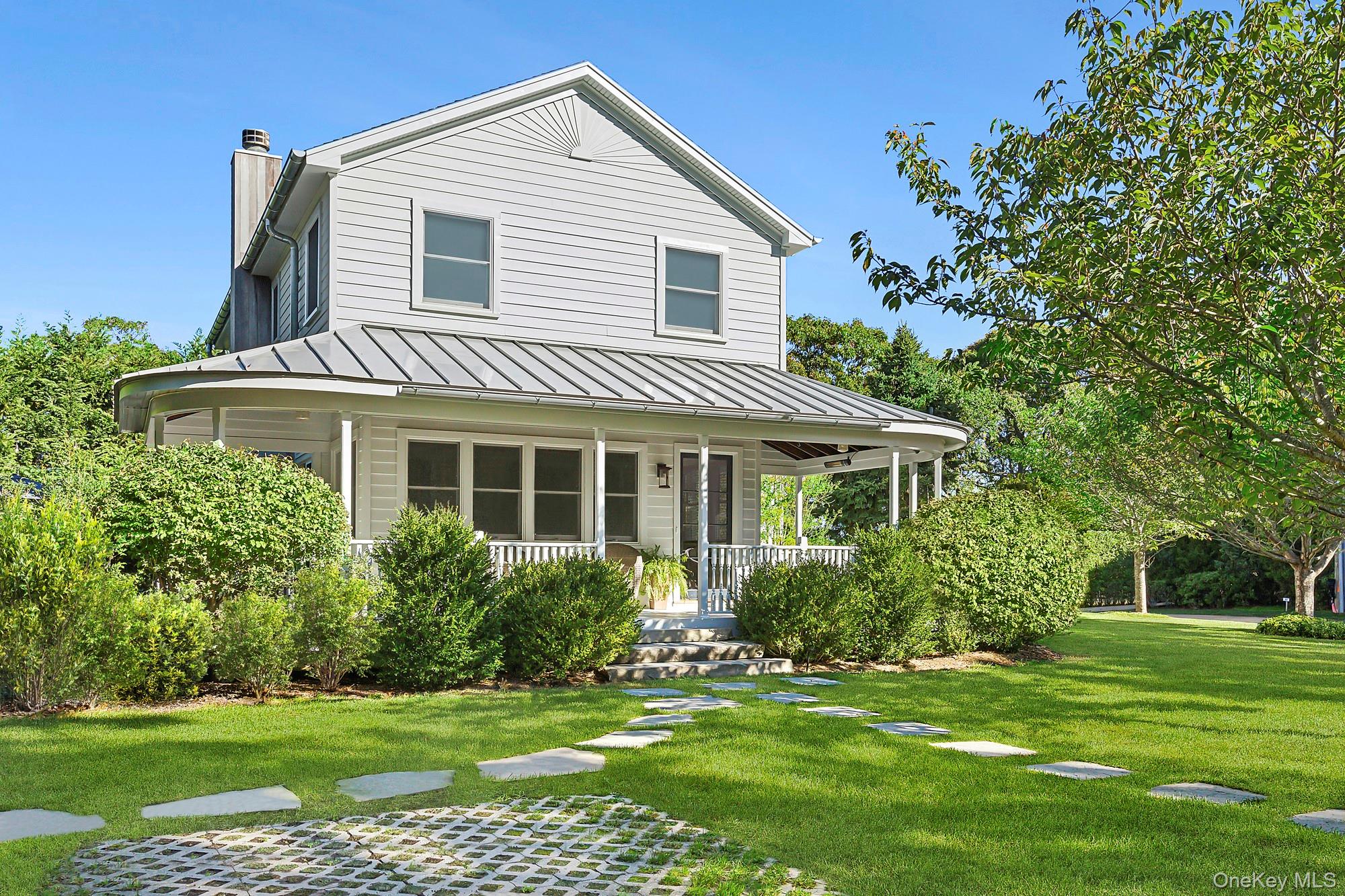 21 Cove Road Sag Harbor, NY 11963 - Photo 2 of 37 View of front of house featuring a standing seam roof, a chimney, a front yard, a metal roof, and covered porch