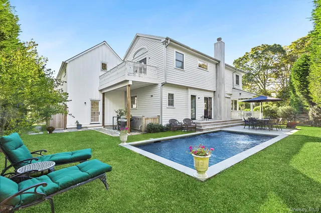 a view of an house with swimming pool and chairs
