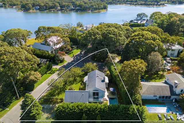an aerial view of a house with outdoor space and lake view