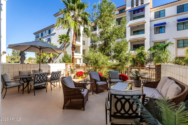 a view of a patio with a dining table and chairs under an umbrella