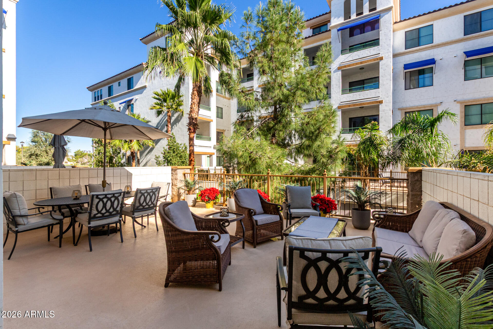 2511 West Queen Creek Road, Unit 124 Chandler, AZ 85248 - Photo 2 of 39 a view of a patio with a dining table and chairs under an umbrella