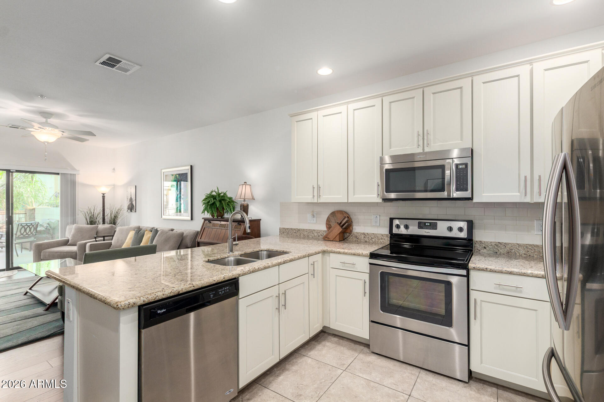 2511 West Queen Creek Road, Unit 124 Chandler, AZ 85248 - Photo 23 of 39 a kitchen with white cabinets stainless steel appliances and sink