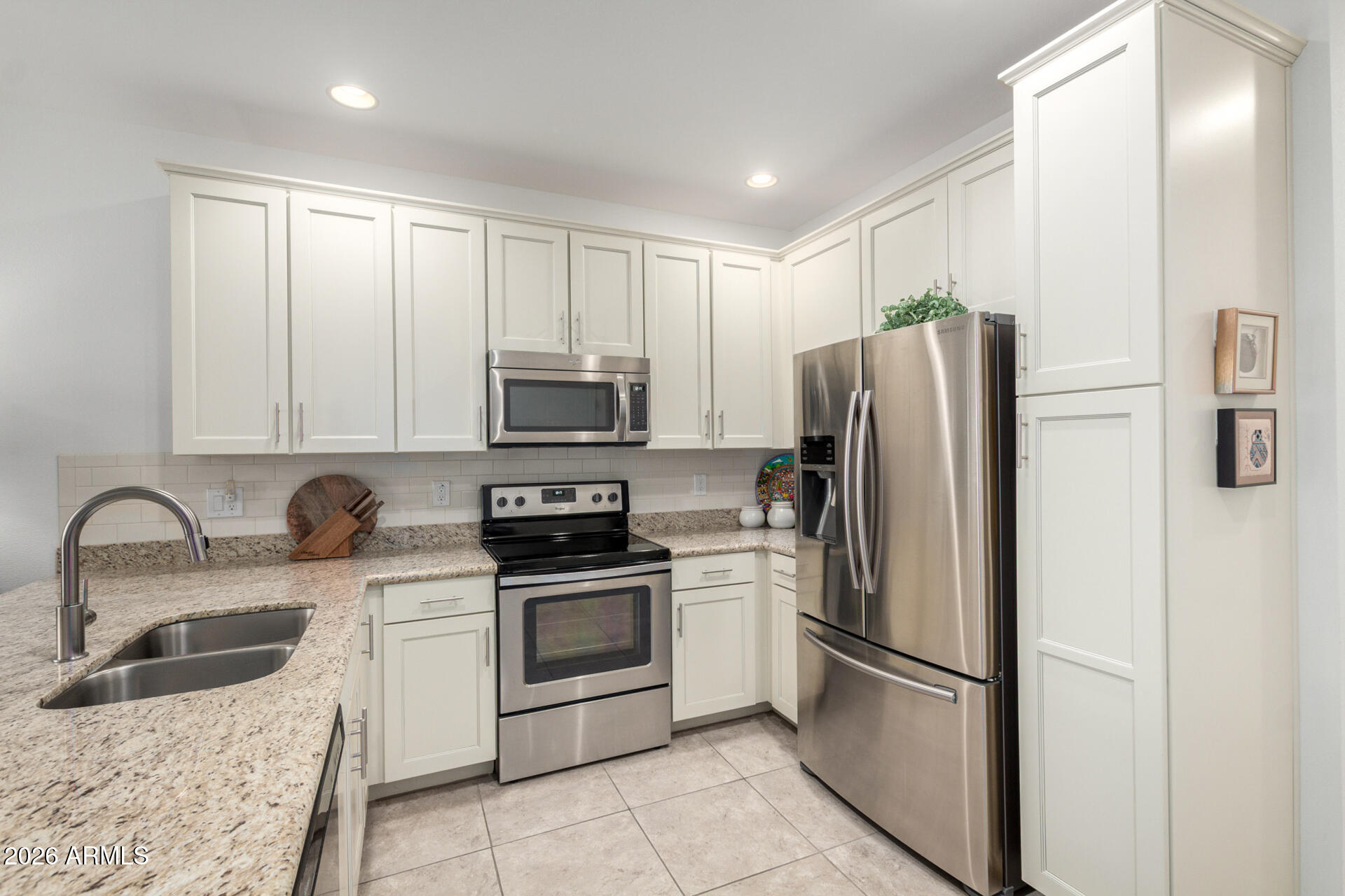 2511 West Queen Creek Road, Unit 124 Chandler, AZ 85248 - Photo 7 of 39 a kitchen with stainless steel appliances granite countertop a refrigerator sink and stove