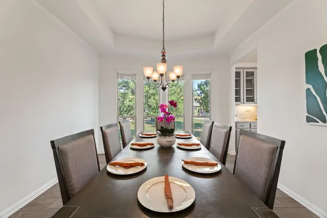 a dining room with furniture potted plants and wooden floor