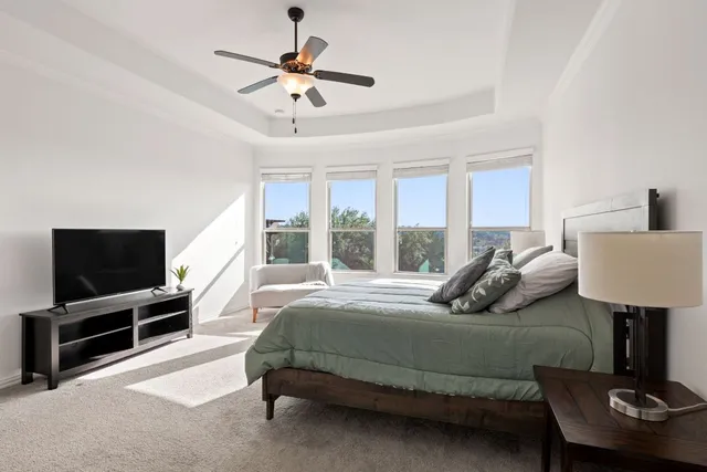 a bedroom with a bed window and a flat screen television